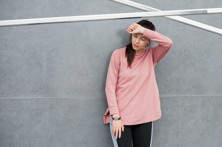 Fitness sport girl resting after intensive evening run, young attractive runner taking break after...