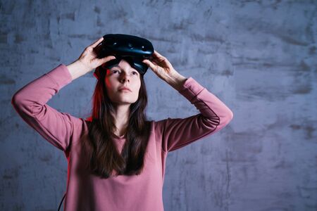 Short break. A delighted girl holds virtual reality glasses on her forehead. She takes off, opens...