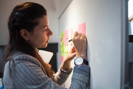 Teamwork, project management, agile methodology. Two young business women in the office are working...