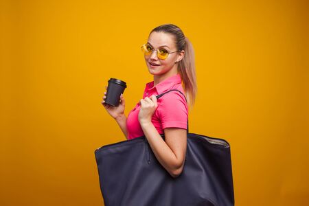 Business positive girl in casual style hurries on business and drinks coffee to take away. Coffee...