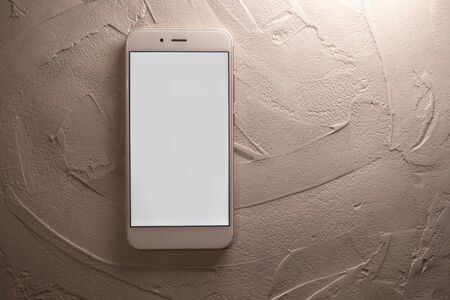 White smartphone on white textured background, contrast light, mockup. Phone, modern technologies social networks and applications. Copy space, white screenの写真素材