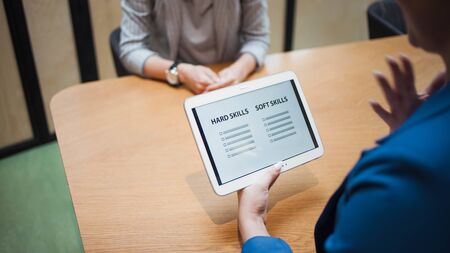 Job interview. The recruiter holds a tablet with a check list of the necessary skills of the...