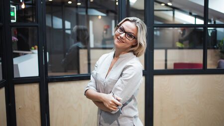 Business blonde in casual clothes in the office. Portrait of a young woman employee of the companyの写真素材
