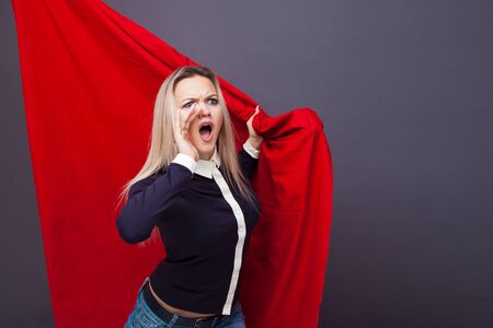 young woman with a red flag, a revolutionary activist, a fighter for rights. Portrait of a determined feminist girl, the concept of the struggle for social justice, copy spaceの写真素材