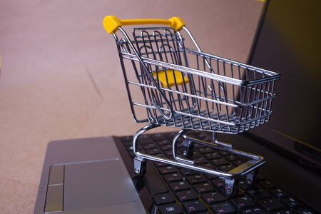 E-Commerce, concept. Online shopping, shopping cart on laptop keyboard. Shopping in online stores and online payments. Empty shopping cart on computer keyboardの写真素材