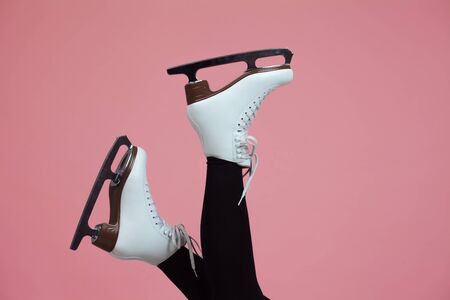 Figure skating is a winter sport and leisure. Women's feet in ice dancing skates. Slender female legs in white skates for figure skating.の写真素材