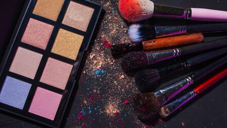 Cosmetics and makeup brushes, professional brushes and palette eye shadow, set on a dark background, copy spaceの写真素材