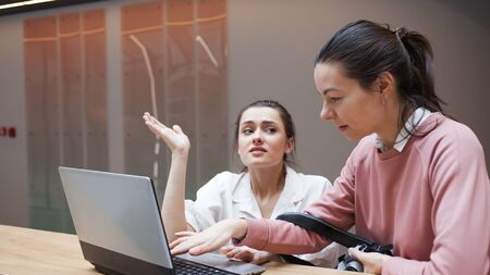 Coaching and mentoring, a professional helps a Junior colleague. The internship concept. Two young...