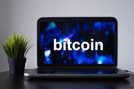 Bitcoin and the cryptocurrency concept. Laptop on the table with the inscription bitcoin