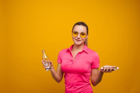 A healthy lifestyle, drink water and use the app for fitness tracking. A young woman with a bottle...