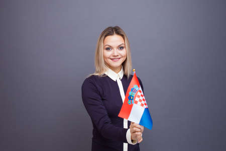 Immigration and the study of foreign languages, concept. A young smiling woman with a Croatia flag...