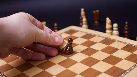 Chess game, check or checkmate, cut a figure, the concept of competition in business. player's hand moves the pieceの写真素材