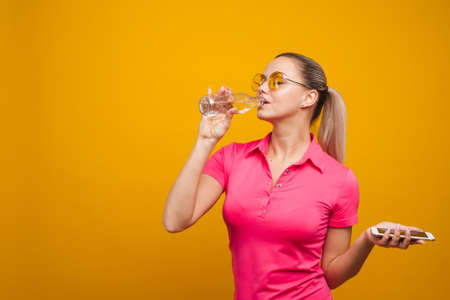 Healthy habits, an app to track the amount of water you drink. Young woman with a bottle of water...