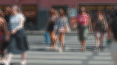 A crowd of people at a pedestrian crossing in the city, a photo in a blur