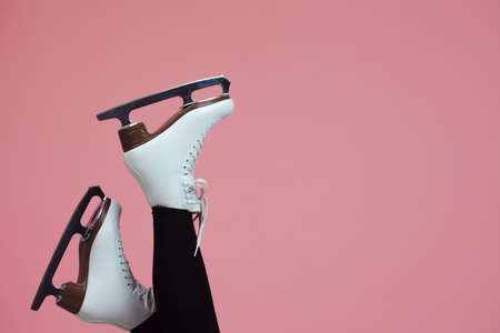 Figure skating is a winter sport and leisure. Women's feet in ice dancing skates. Female figure skater, legs on a pink background.の写真素材