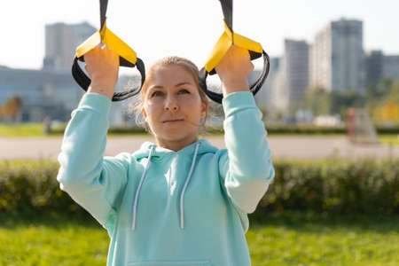 Outdoor fitness, public sports field. A young sportswoman do a workout on the street, a healthy...