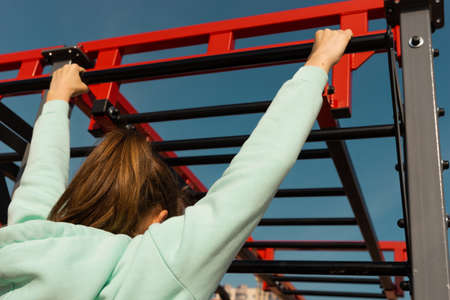 Outdoor fitness, public sports field. A young sportswoman does a workout on the street, a healthy lifestyle.の写真素材
