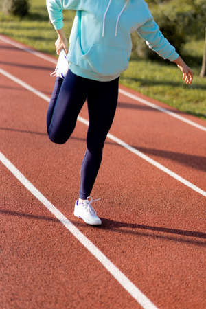 Outdoor fitness, public sports field. A young sportswoman does a workout on the street, a healthy...
