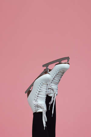 Figure skating is a winter sport and leisure. Womens feet in ice dancing skates. Slender female legs in white skates for figure skating.の写真素材