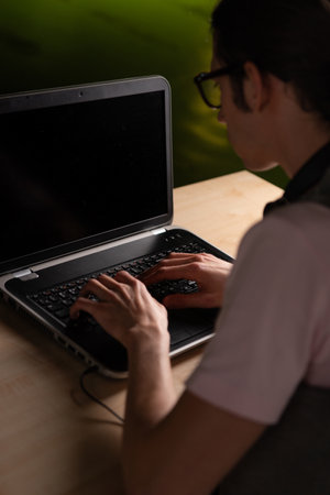 Write code and learn programming languages. A student or specialist is doing a project. The guy is a programmer working on a laptopの写真素材