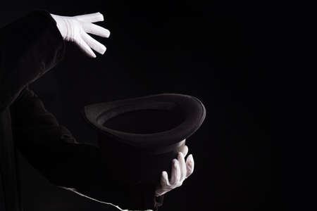 Hand gestures. The magician shows tricks with a hat. Black backgroundの写真素材