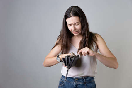 Spending exceeds income, sad young woman is engaged in the management of the family budget,の写真素材