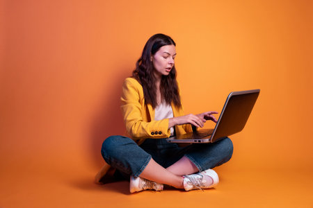 freelancer at a laptop, a young specialist working remotely. A young woman in modern-style clothingの写真素材