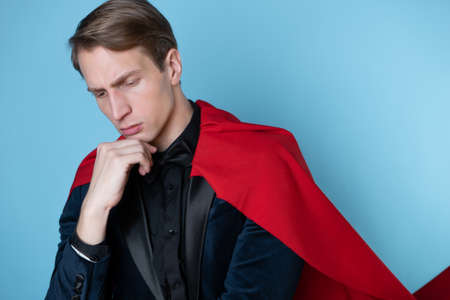 businessman in a suit with a red cape in the image of a superhero, thought about the problem,の写真素材
