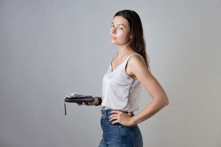 Counting money, maintaining a personal budget, concept. A young woman with a purse in her hands,