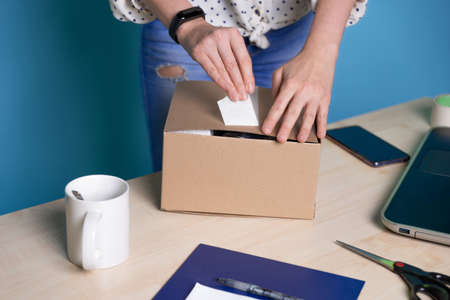 Small business, young female entrepreneur at the table packing a small boxの写真素材