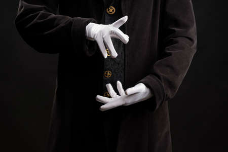 Hand gestures. Showman or magician illusionist in white gloves on a black background.