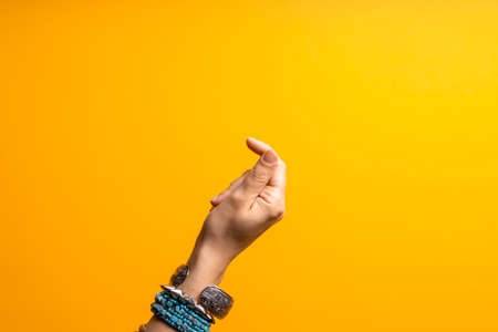 Hand gestures. Click your finger. Womens hand with lots of bracelets, youth fun style.の写真素材
