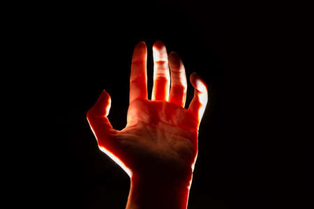 magical reddish light shines from above on the palm of your hand. Open palm, free space for design.の写真素材