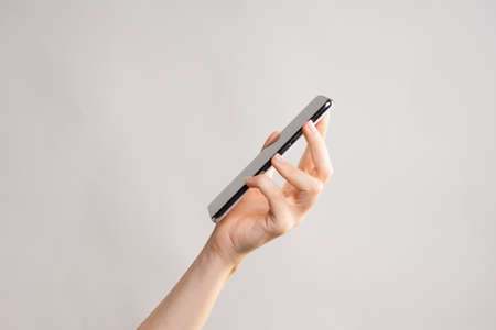 Slim modern smartphone in a womans hand, use the Internet or apps on your phone.