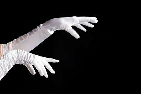 Hand gestures. lady in long white gloves points to the side, a show of magic.の写真素材