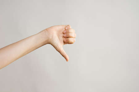 Hand gestures. Thumbs down, dislike disapproval. womens handの写真素材