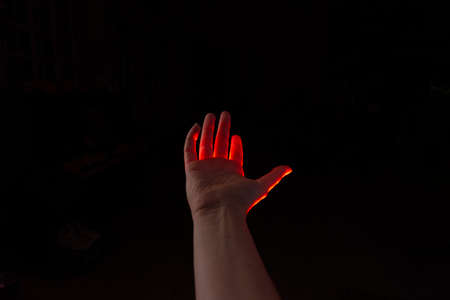 magical reddish light shines from above on the palm of your hand. Open palm, free space for design.の写真素材