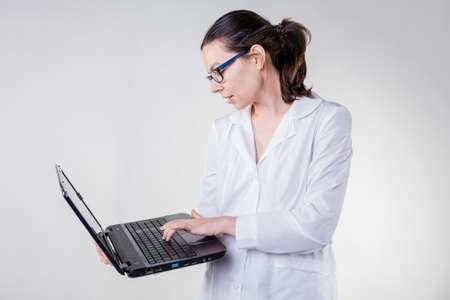 Laboratory assistant or research student in a white coat. A young female doctor in a white coatの写真素材