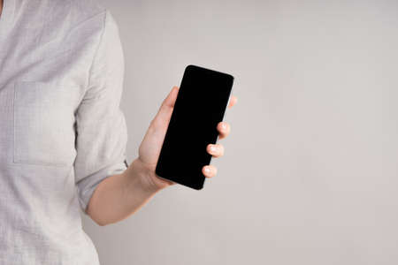 smartphone with a touch screen in a womans hand. Use your phone with a touchpad, layout for your...