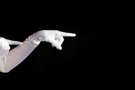 Hand gestures. lady in long white gloves points to the side, a show of magic.の写真素材
