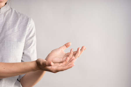 Elegant female hand, pointing to the side. palm holds something, a blank for the design.の写真素材