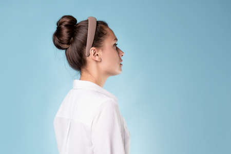 calm portrait in profile, a young beautiful woman in a white shirt,