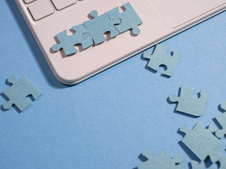 Puzzle elements on a laptop keyboard, software development, concept.
