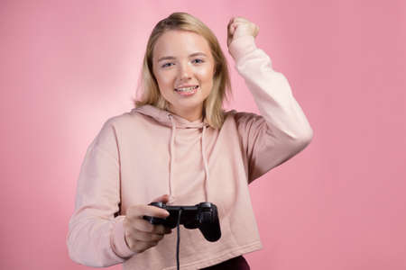 Play and win, a young female gamer is happy to win the game, positive emotions