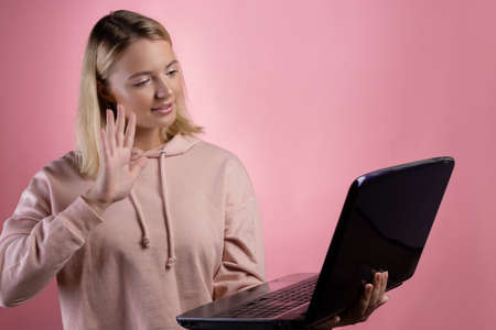 young woman with a laptop, a student or a freelancer uses video communication,