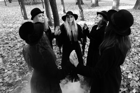 Coven of witches, a group of friends as witches on Halloween perform a ritual, lead a round dance and recite spells.の写真素材