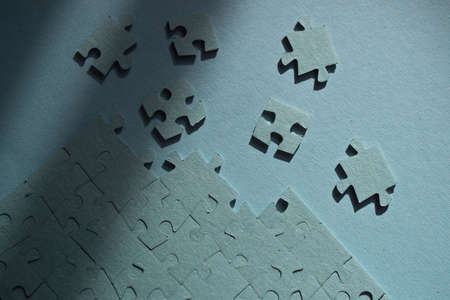 A set of puzzles, the process of collecting in a large pattern. Teamwork and problem solving, concept. Blue mosaic on blueの写真素材