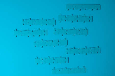 Block chains, a metaphor of the blockchain illustrated with chains of assembled puzzles. Several mosaic elements in a line, on a blue backgroundの写真素材