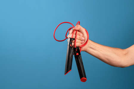 Actively move and be healthy, sports and a healthy lifestyle, concept. A mans hand holds a rope in...