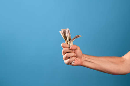 Take my money, the willingness to pay for a cool product, a concept. A mans hand clutches a wad of...